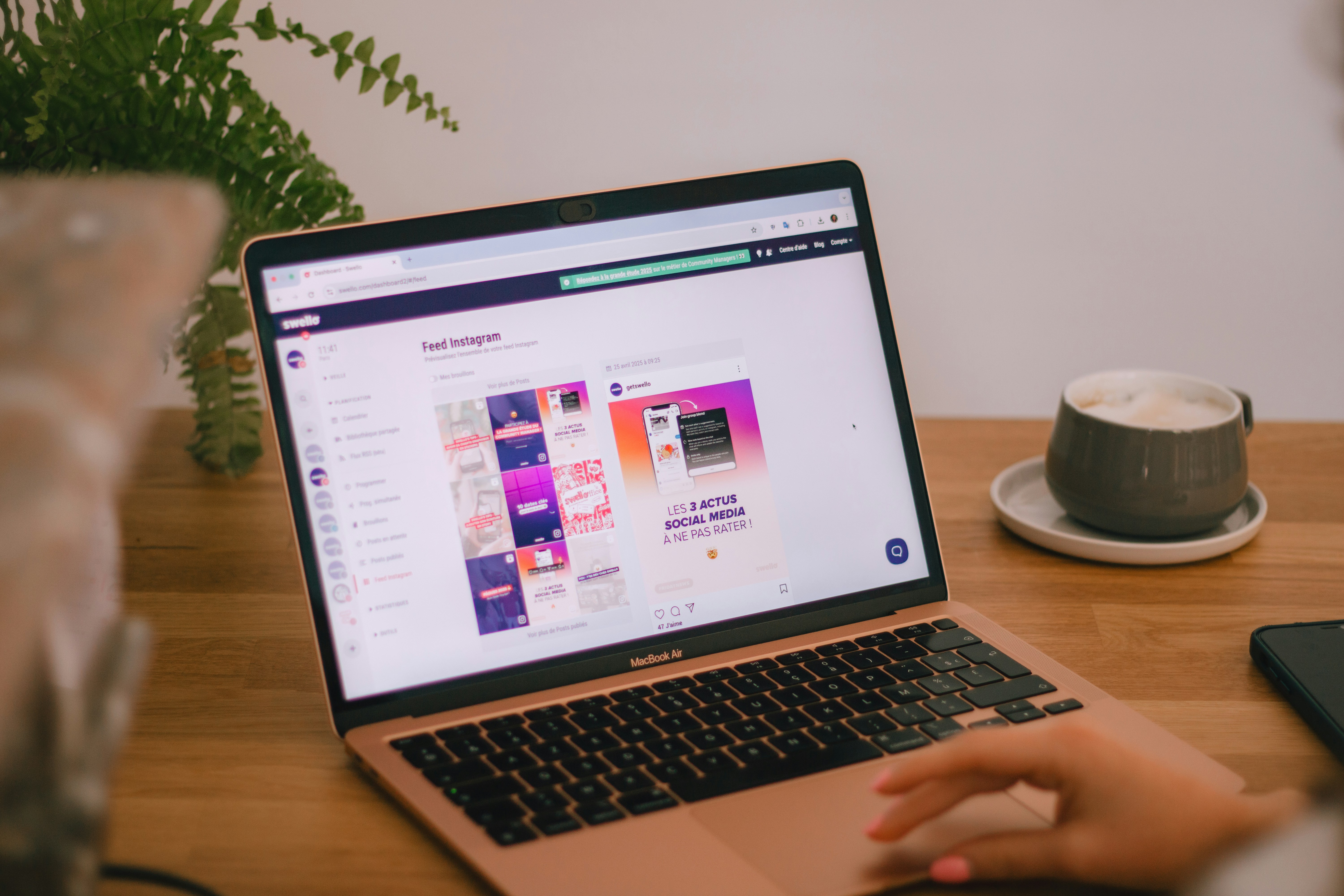 Persona haciendo scroll en un portátil con un listado largo tipo feed y un botón “Cargar más” visible en la parte inferior, en un entorno de trabajo real
