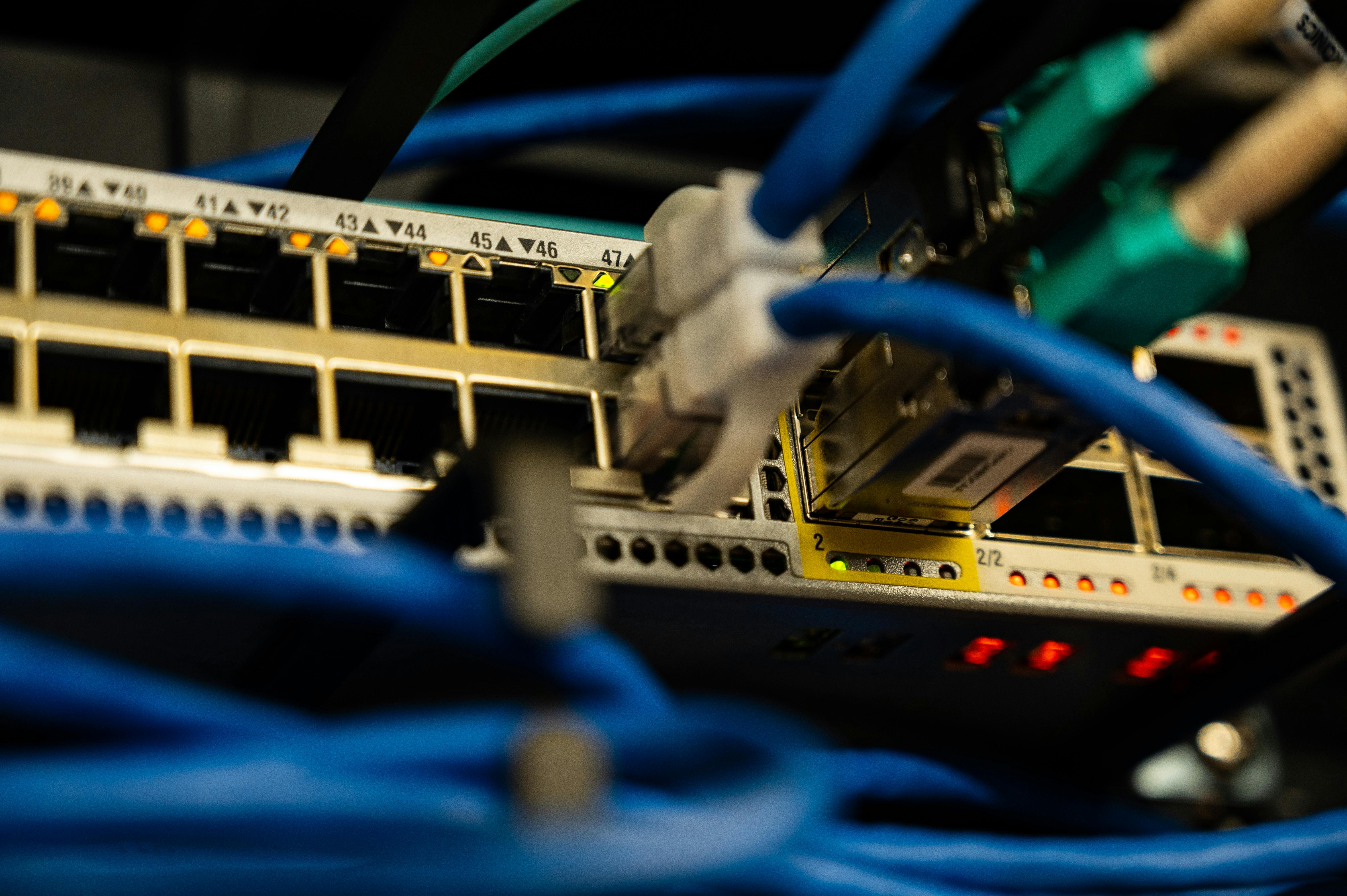 Cables ethernet de colores conectados a un switch de red en un centro de datos