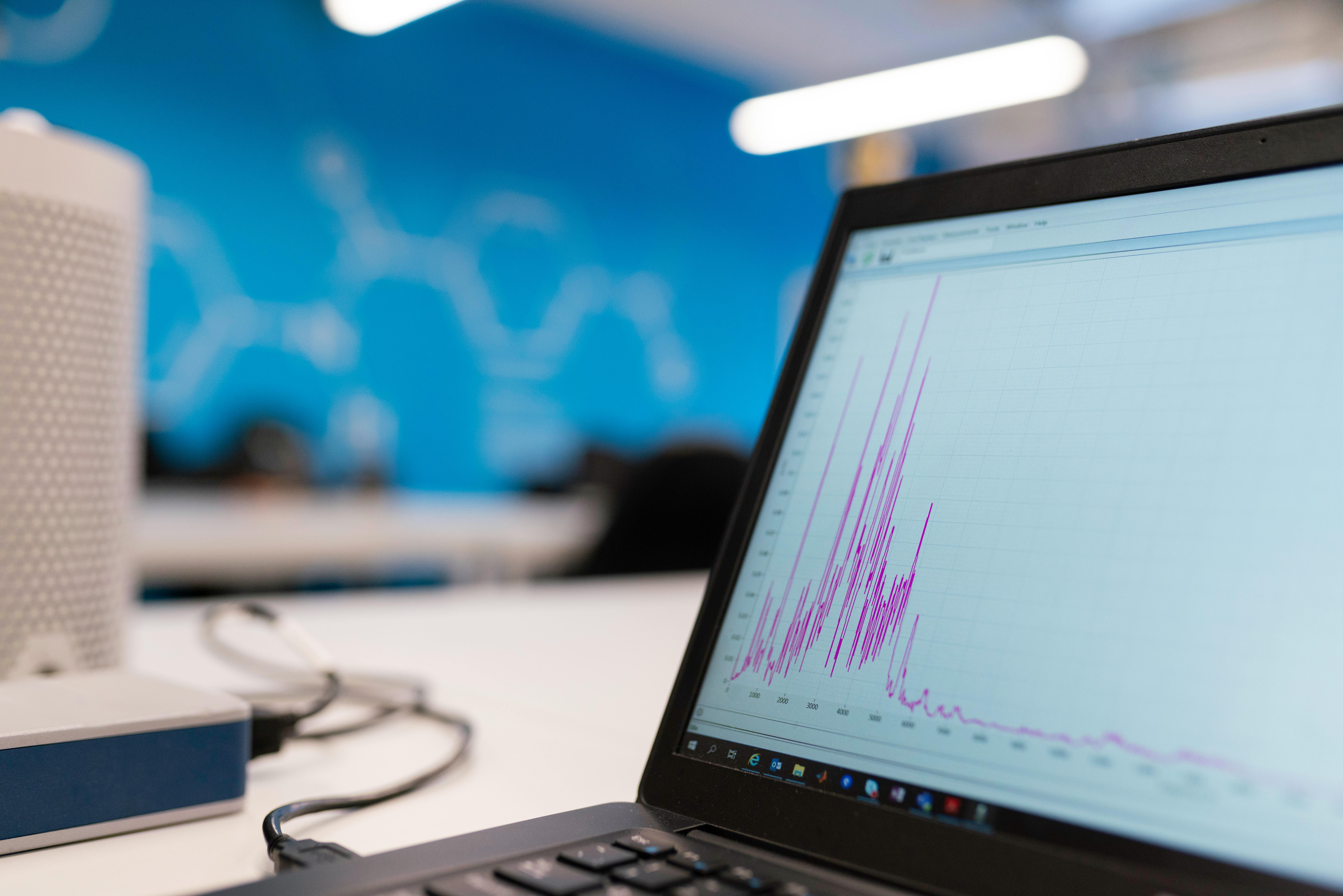 Pantalla de portátil mostrando gráficas de analítica web con líneas de datos ascendentes