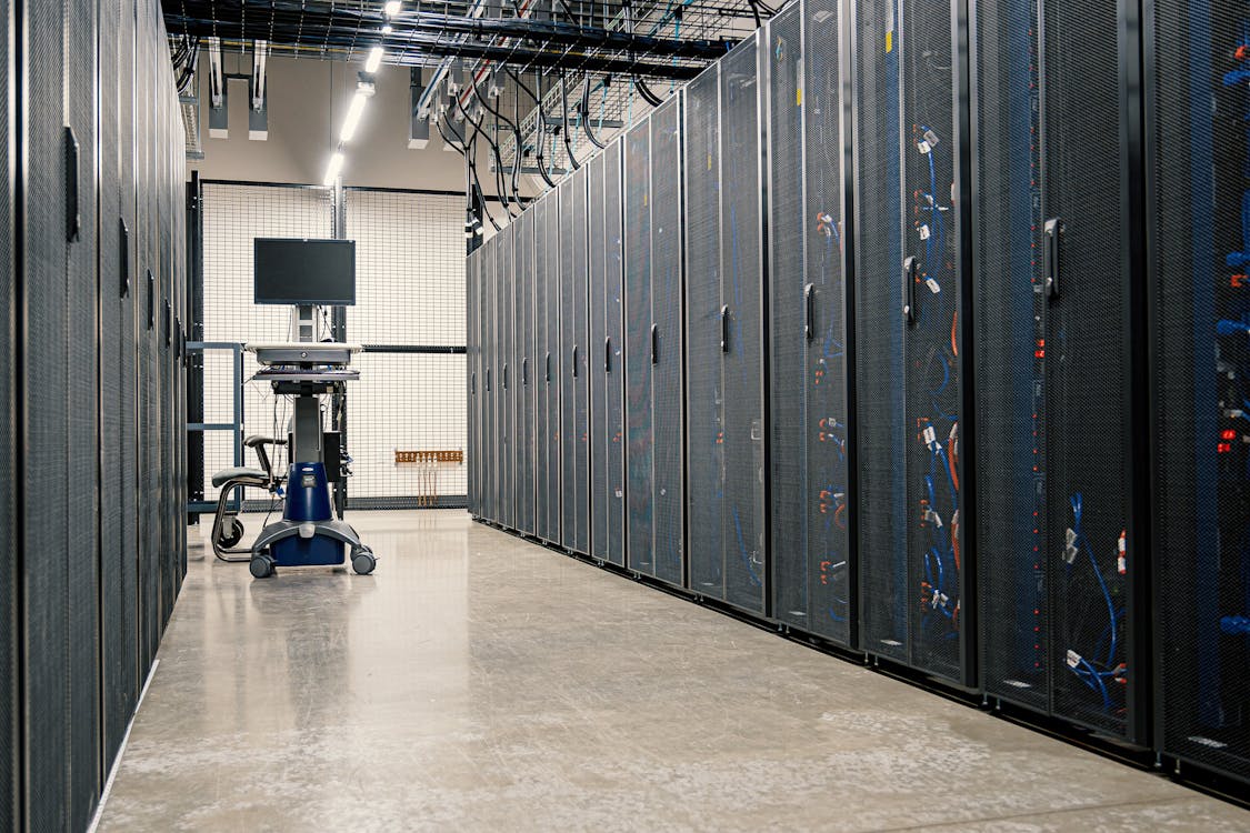 Racks de servidores iluminados en un centro de datos, vistos en perspectiva desde un pasillo estrecho