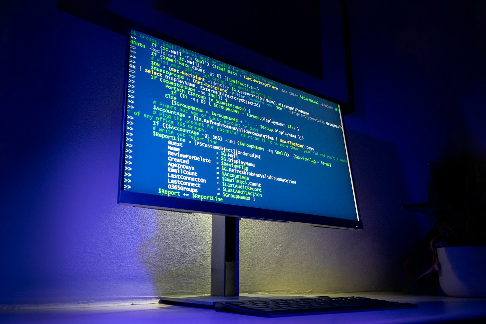 Monitor con código fuente en editor dark theme, iluminación azul profesional para desarrollo web