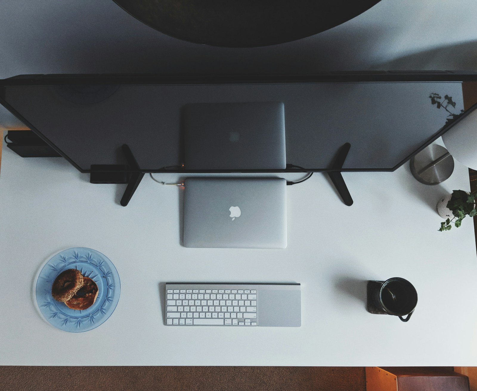 Escritorio minimalista con portátil, teclado y monitores para desarrollo y cumplimiento normativo